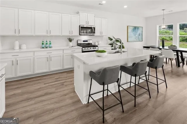 a kitchen with a stove and a white wooden cabinets