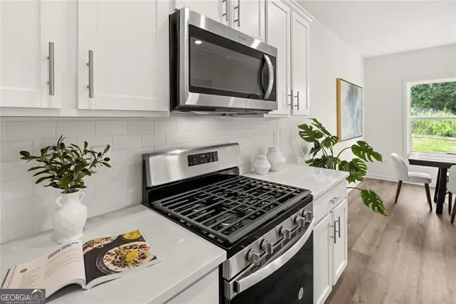 a view of a dining room with furniture a potted plant and a chandelier