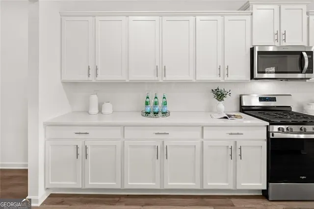 a living room with stainless steel appliances kitchen island granite countertop furniture a rug kitchen view and a chandelier