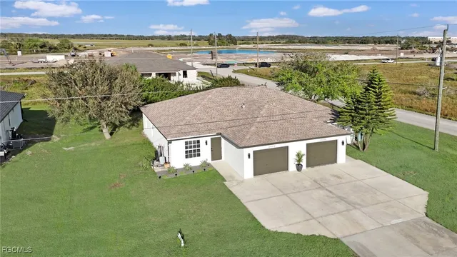 a aerial view of a house with a yard and lake view