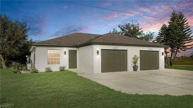 a front view of a house with a yard and garage