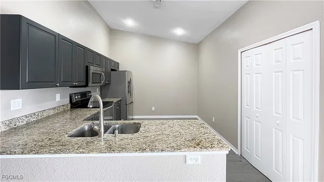 a kitchen with a sink a counter top space appliances and cabinets