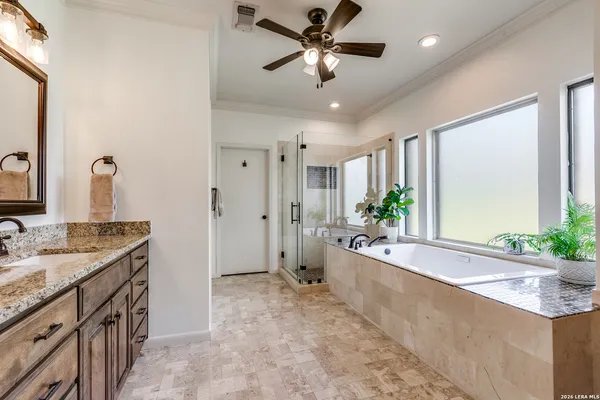 a spacious bathroom with a granite countertop tub a double vanity sink a large mirror and a shower