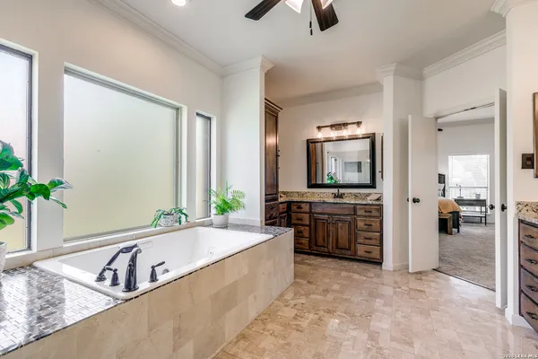 a spacious bathroom with a tub a sink and a large mirror