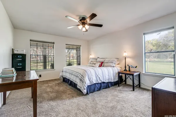 a spacious bedroom with a bed window and a table