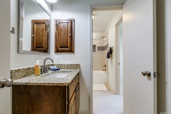 a bathroom with a granite countertop sink and a mirror