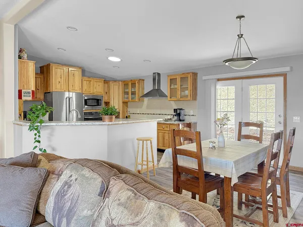 a dining room with furniture a chandelier and wooden floor