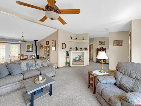 a living room with furniture a flat screen tv and a wall painting