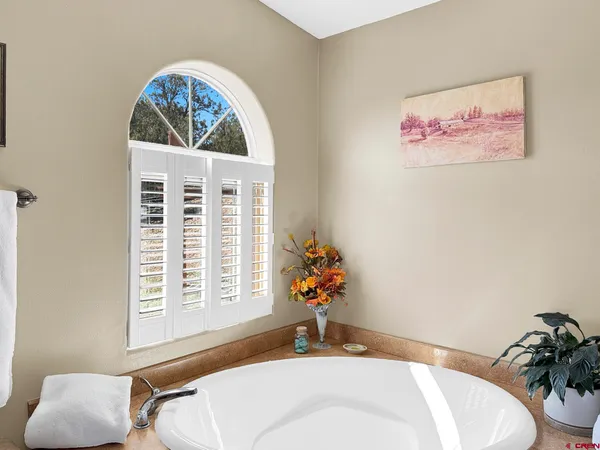 a bathroom with a tub sink and mirror
