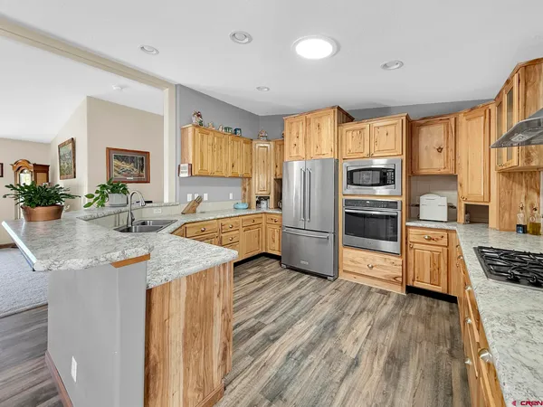 a kitchen with granite countertop a refrigerator stove top oven and sink