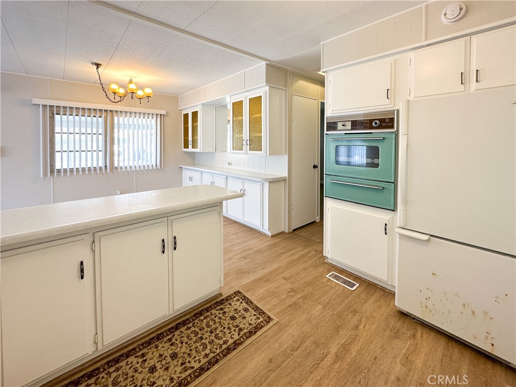 80 Huntington Street, Unit 707 Huntington Beach, CA 92648 - Photo 8 of 16 a kitchen with granite countertop white cabinets and white appliances