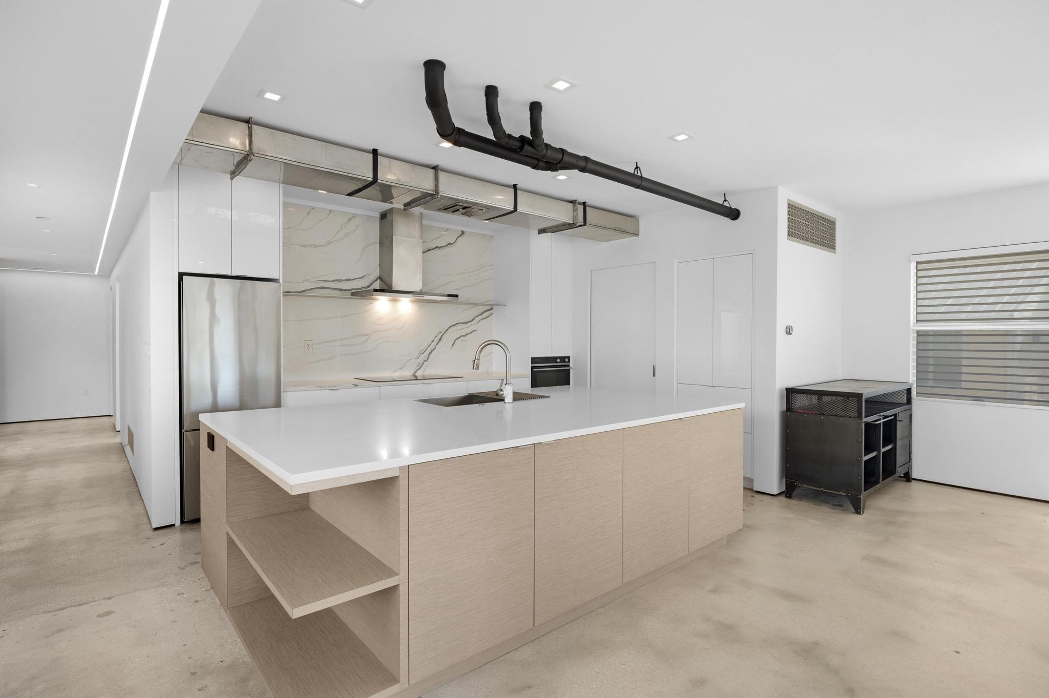 105 Front Street, Unit 122 Key West, FL 33040 - Photo 13 of 52 a large white kitchen with a sink and refrigerator