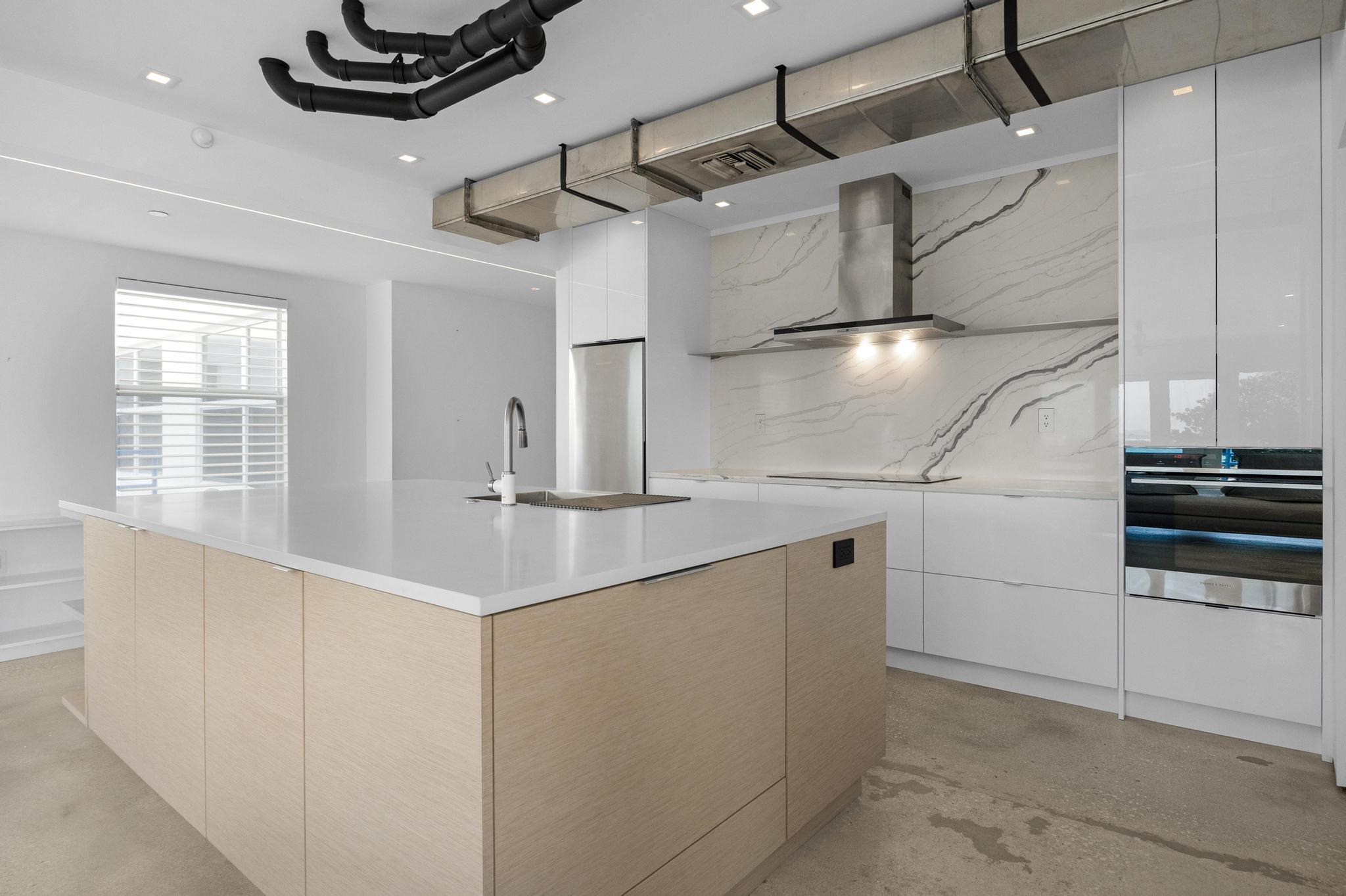 105 Front Street, Unit 122 Key West, FL 33040 - Photo 15 of 52 a kitchen with stainless steel appliances a sink a stove and a refrigerator