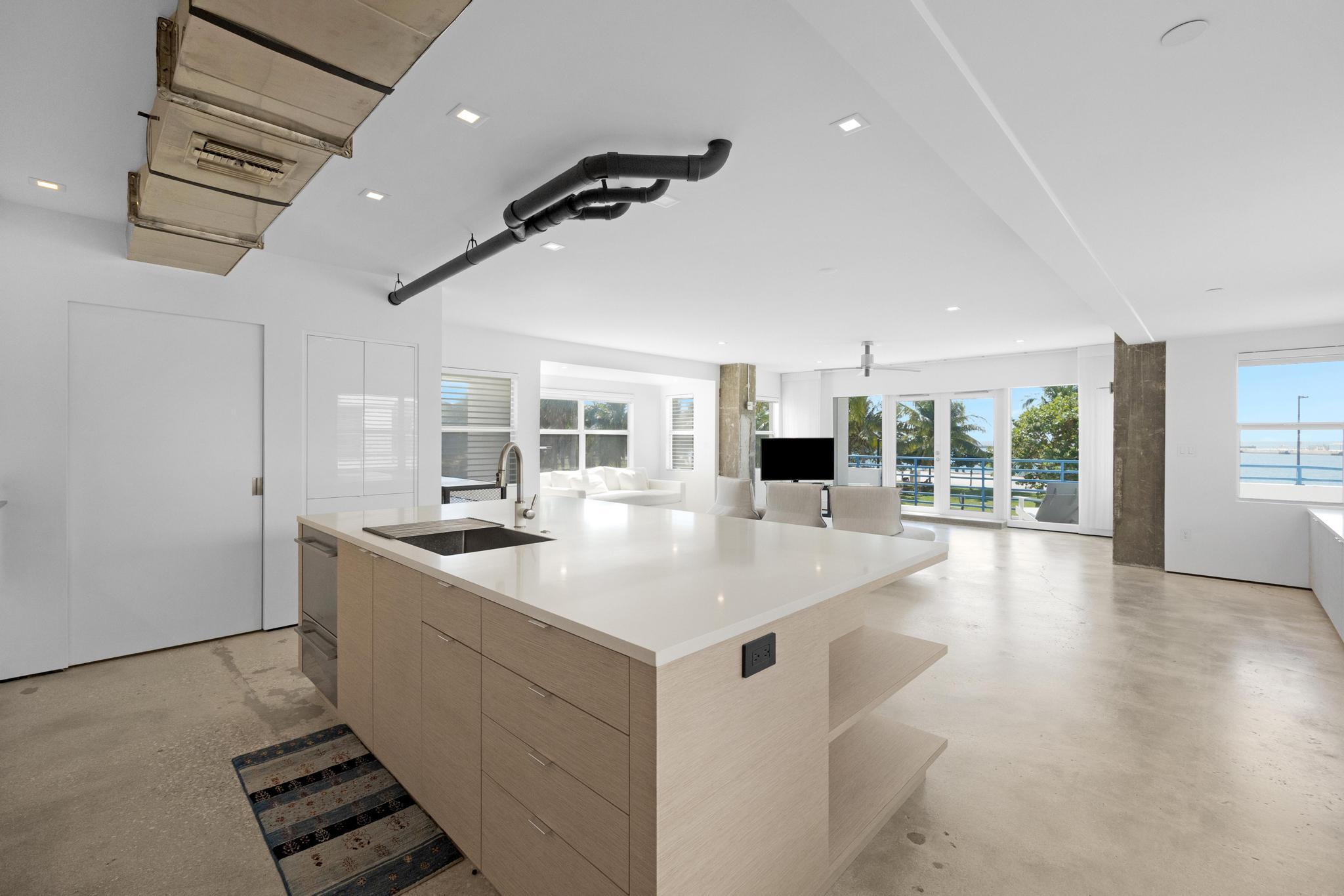 105 Front Street, Unit 122 Key West, FL 33040 - Photo 2 of 52 a very nice looking room with kitchen island furniture and a wooden floor