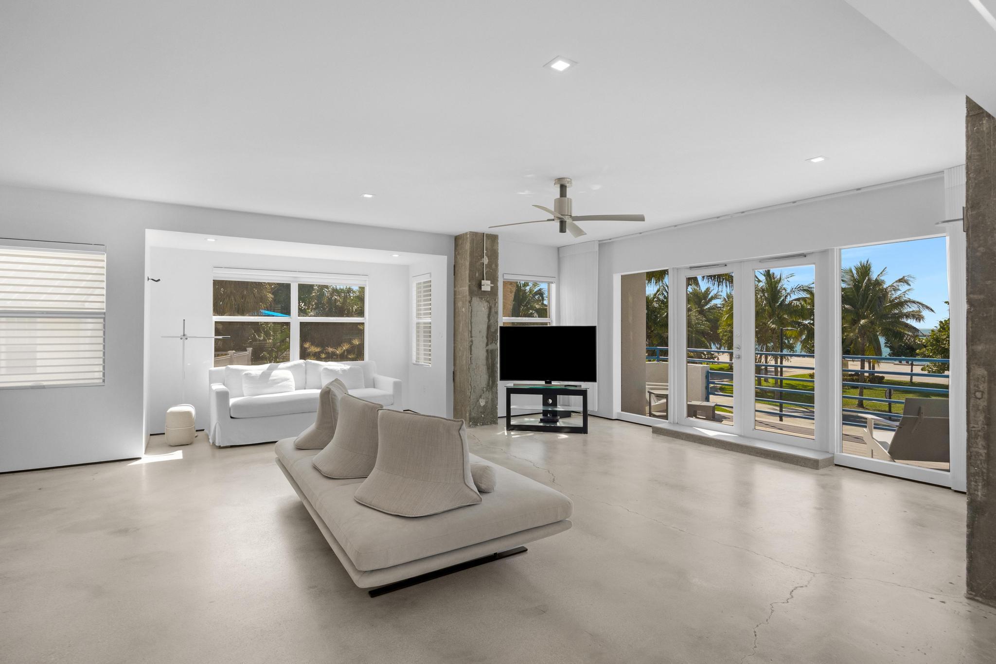 105 Front Street, Unit 122 Key West, FL 33040 - Photo 3 of 52 a living room with furniture large windows and flat screen tv