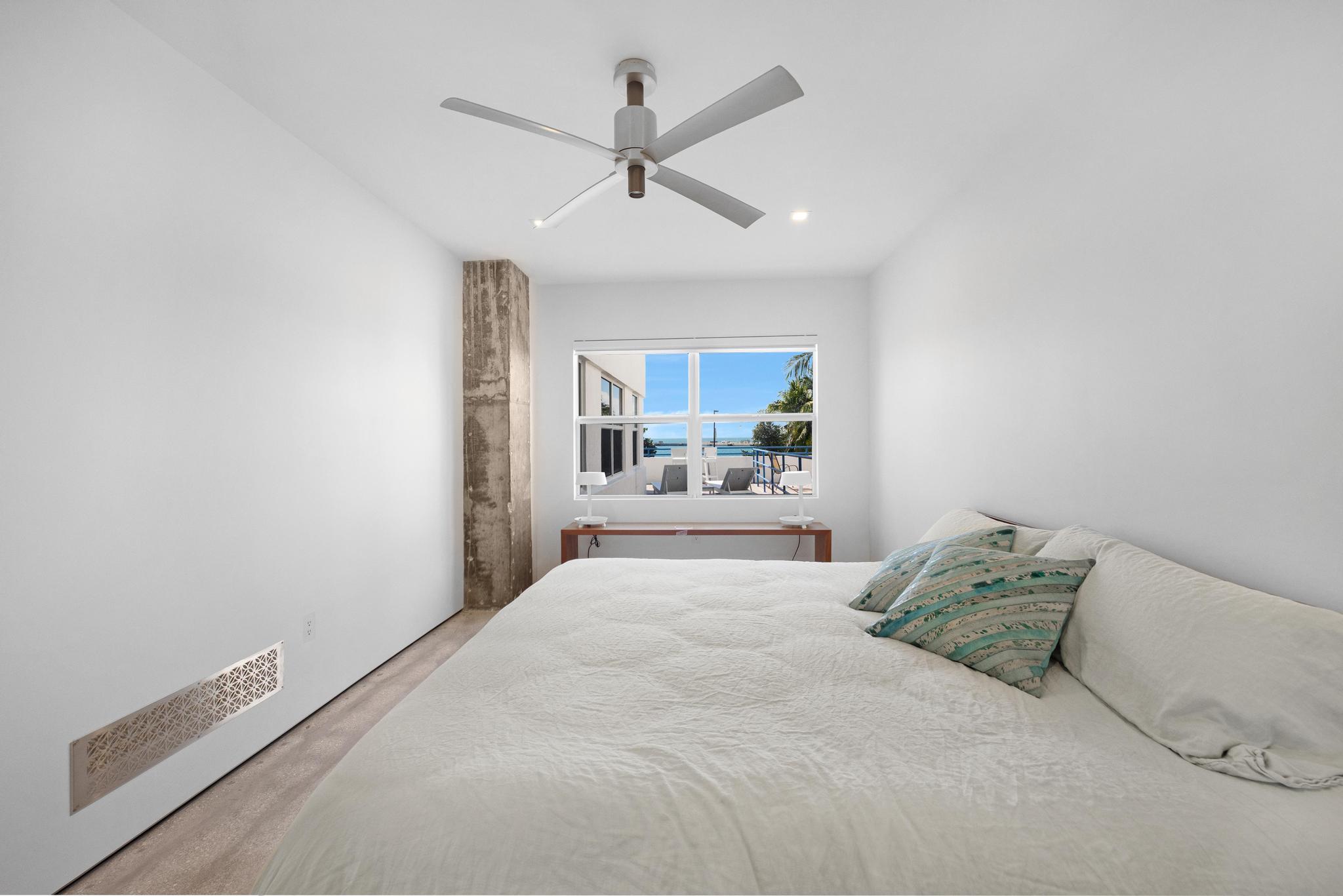 105 Front Street, Unit 122 Key West, FL 33040 - Photo 37 of 52 a bedroom with a large bed and a chandelier