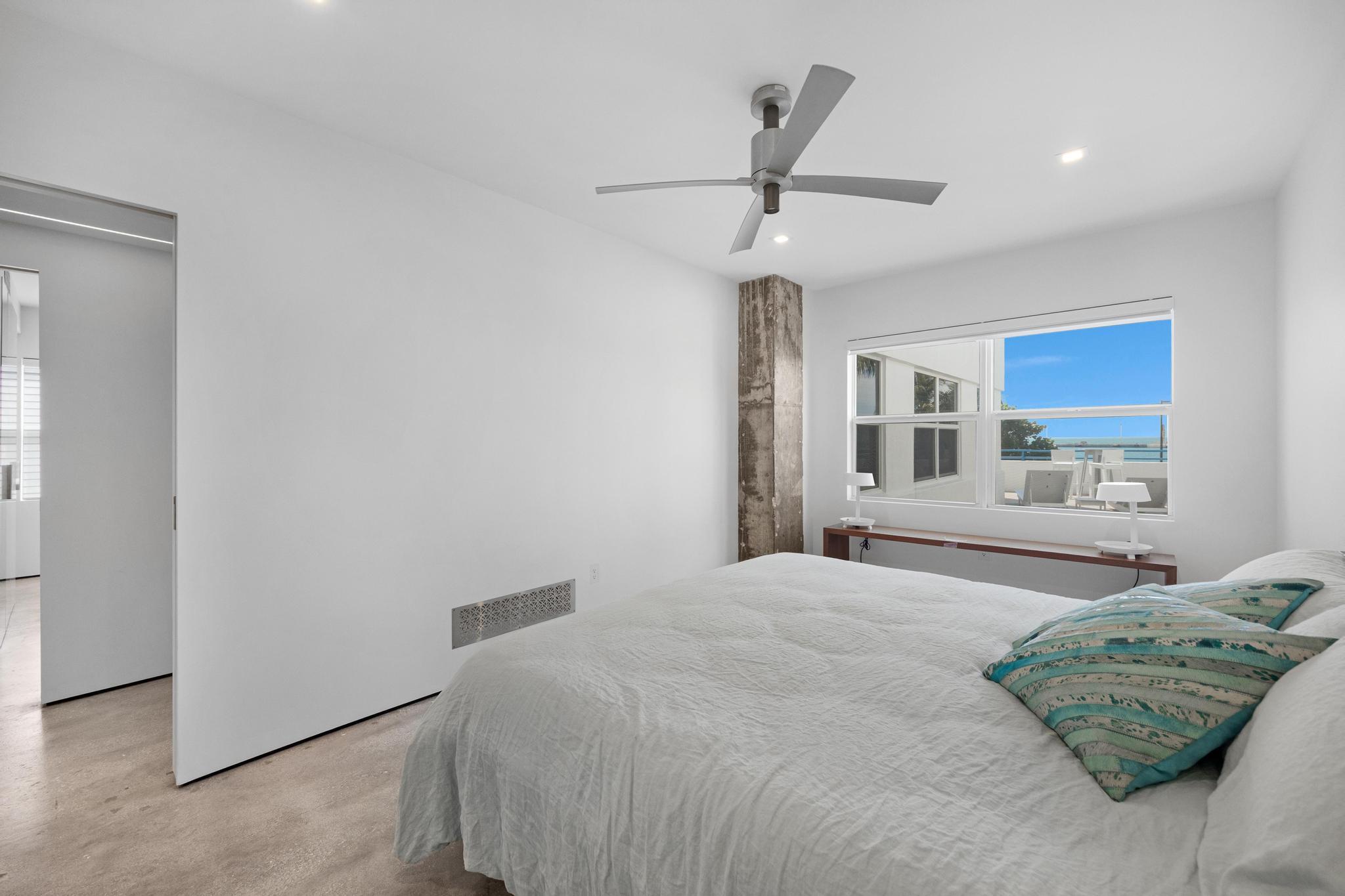 105 Front Street, Unit 122 Key West, FL 33040 - Photo 38 of 52 a bedroom with a large bed and a chandelier