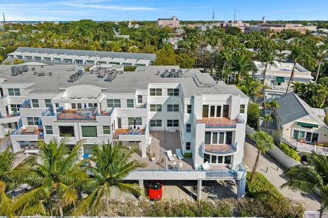 an aerial view of multiple houses with a yard