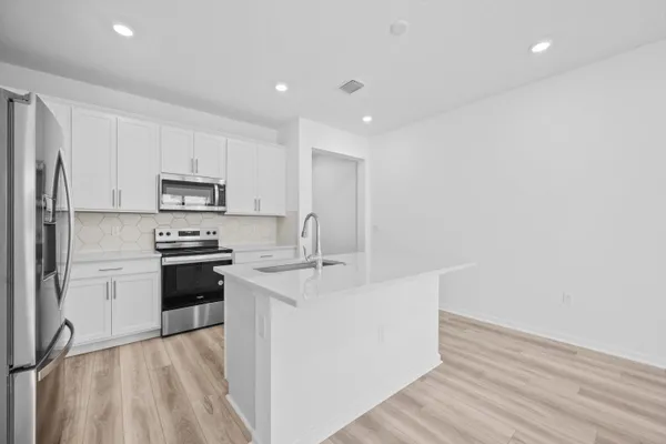 a kitchen with stainless steel appliances a sink stove and refrigerator