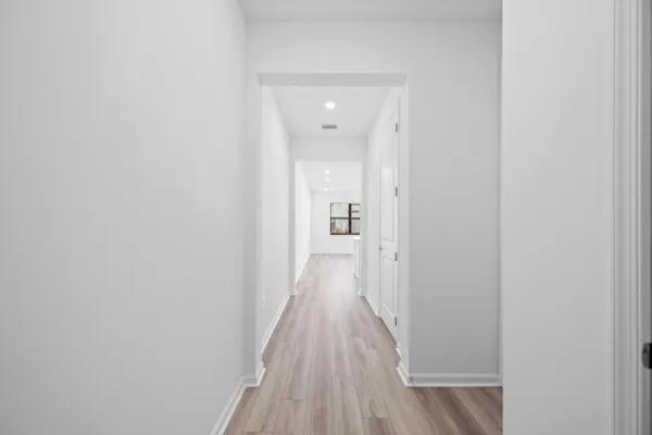 a view of a hallway with wooden floor