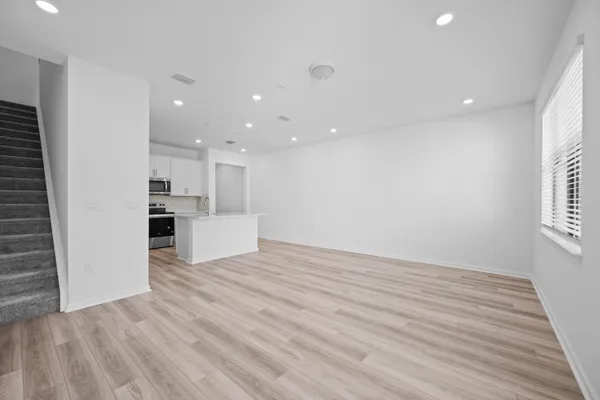 a view of a kitchen with wooden floor and a window