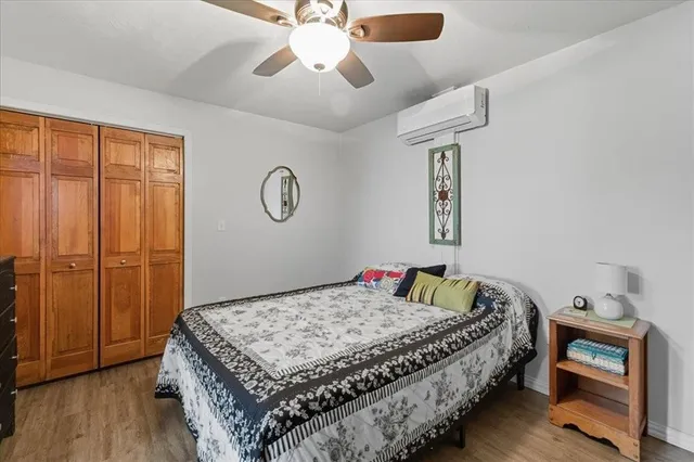 a bedroom with a bed dresser and wooden floor