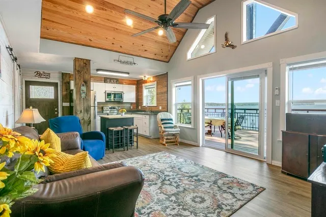 a living room with furniture floor to ceiling window and wooden floor