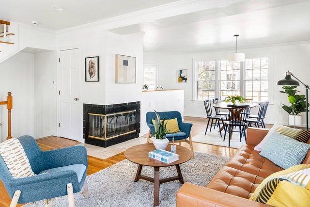 a living room with furniture a fireplace and a chandelier