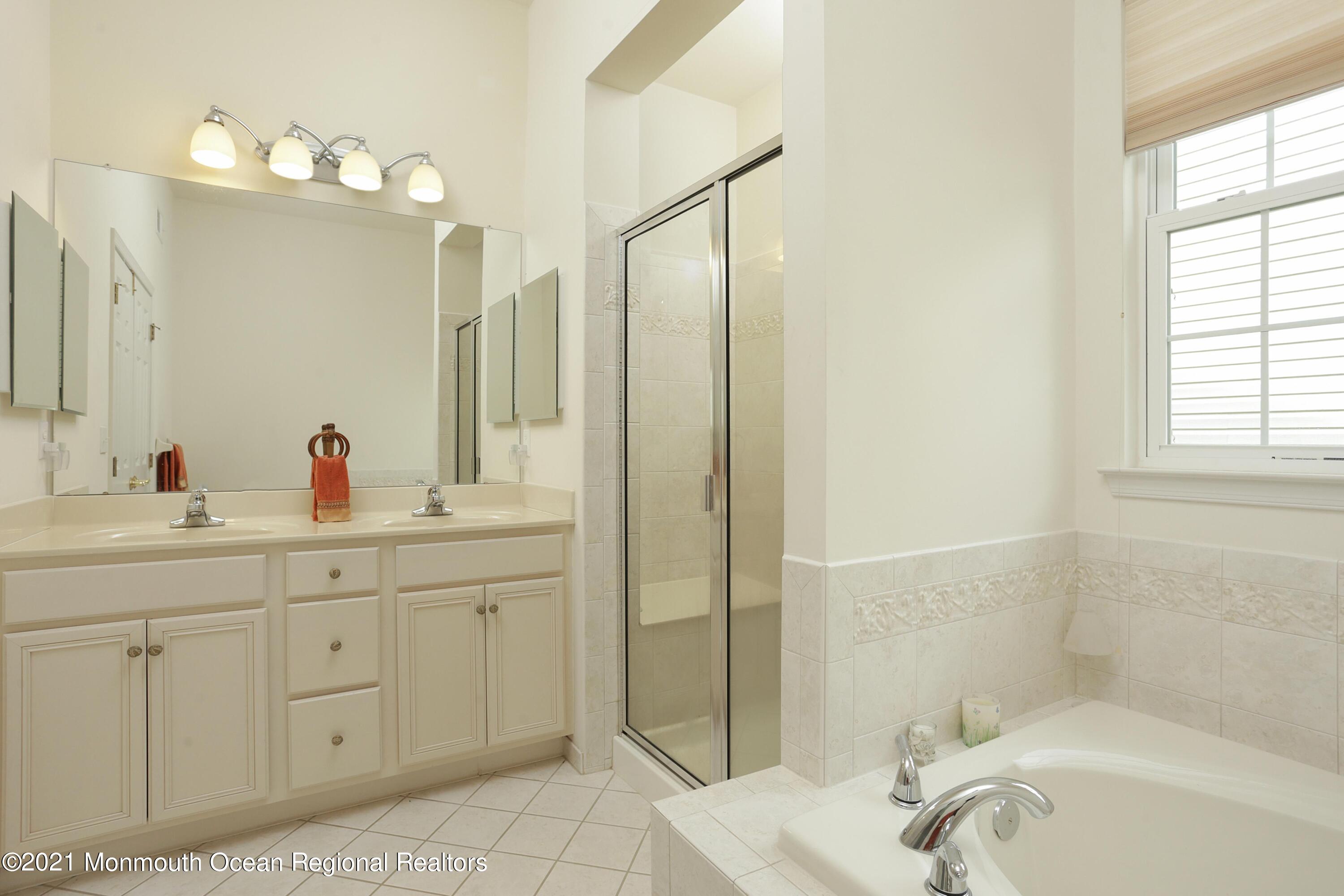21 Crooked Stick Road Jackson, NJ 08527 - Photo 18 of 37 a bathroom with a tub sink and mirror