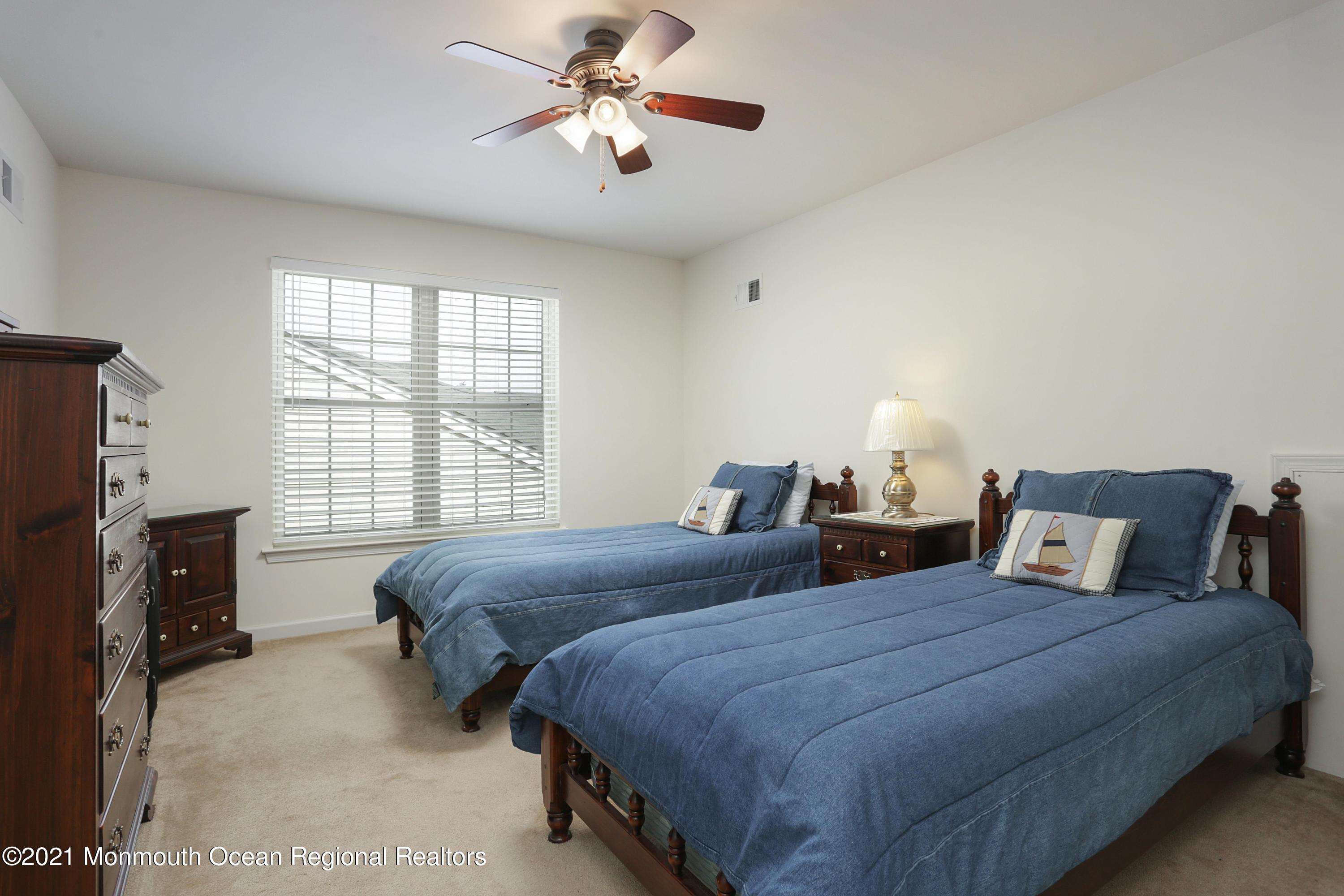 21 Crooked Stick Road Jackson, NJ 08527 - Photo 26 of 37 a bedroom with two beds and a chandelier