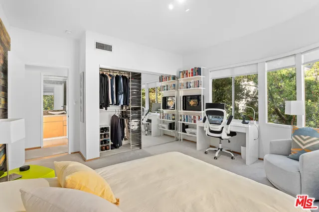 a living room with furniture a large window and gym equipment