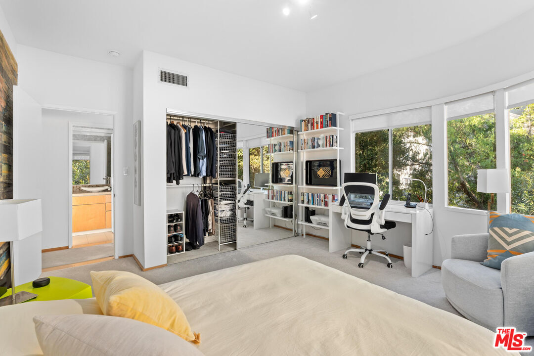 10045 Reevesbury Drive Beverly Hills, CA 90210 - Photo 12 of 32 a living room with furniture a large window and gym equipment