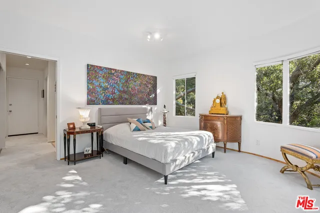 a spacious bedroom with a bed and a large window