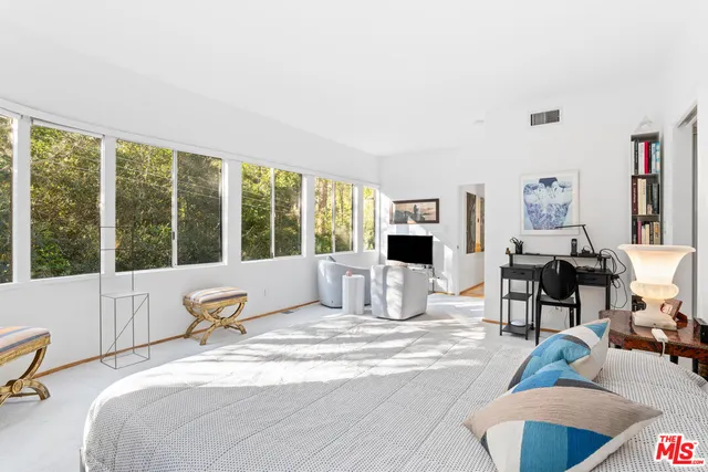 a bedroom with furniture and a large window