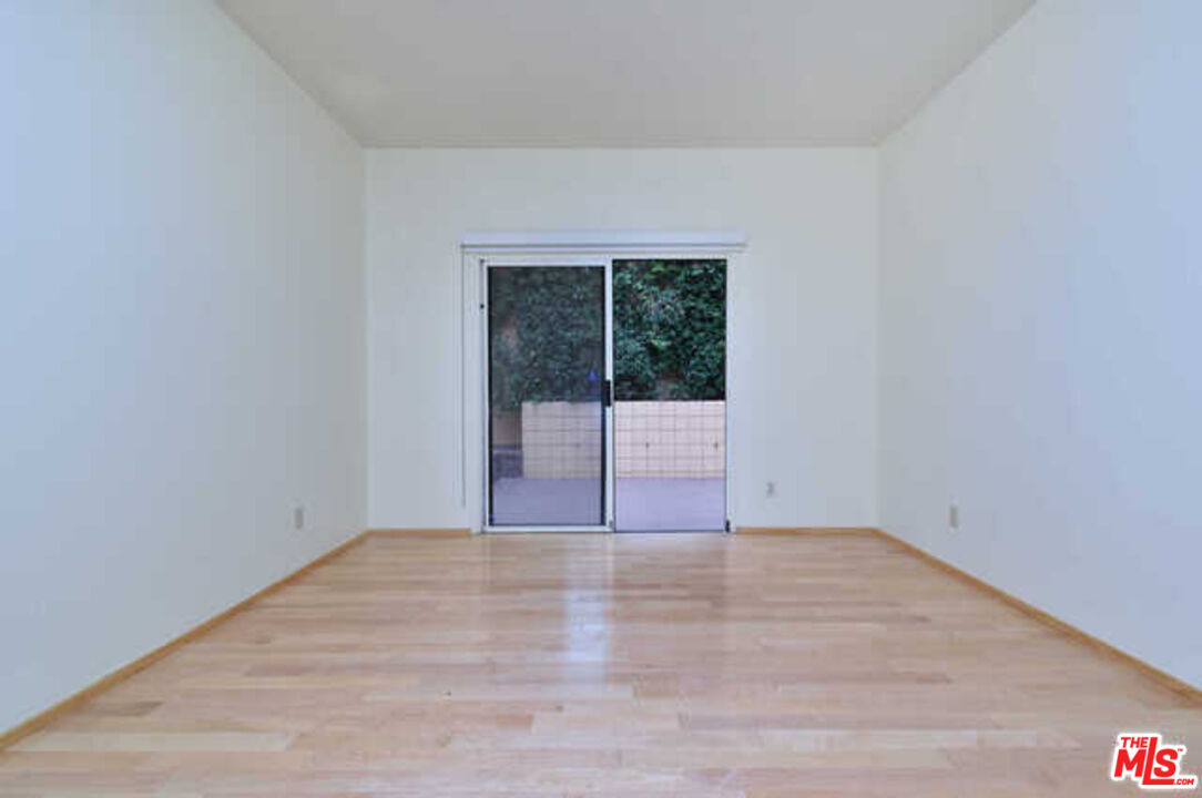 10045 Reevesbury Drive Beverly Hills, CA 90210 - Photo 22 of 32 a view of an empty room with wooden floor and a window
