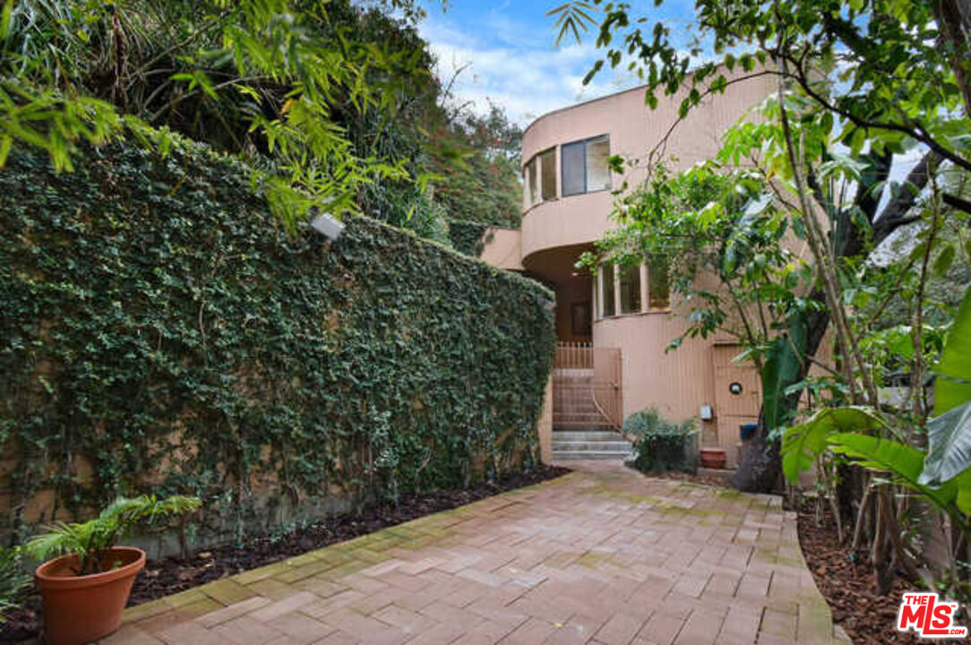 10045 Reevesbury Drive Beverly Hills, CA 90210 - Photo 28 of 32 a view of a white house with a plants and potted plants