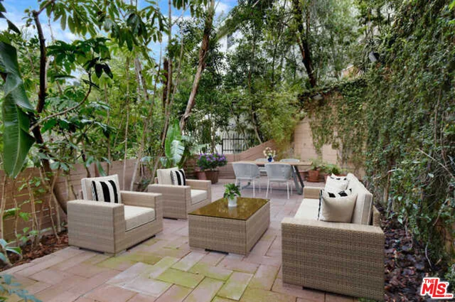 a view of a chairs and table in the backyard