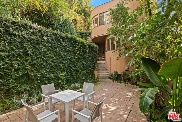 a view of a patio with table and chairs with wooden fence
