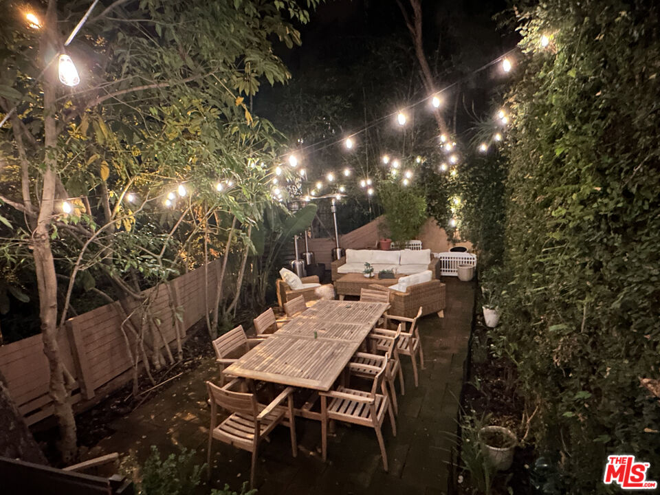 10045 Reevesbury Drive Beverly Hills, CA 90210 - Photo 31 of 32 a view of a patio with table and chairs with wooden fence