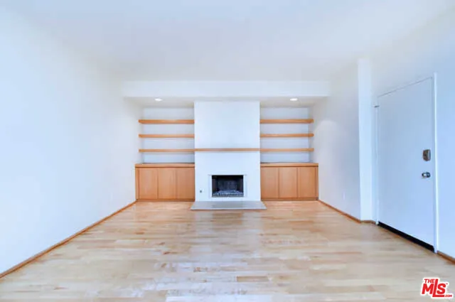 a view of an empty room with a fireplace and a window