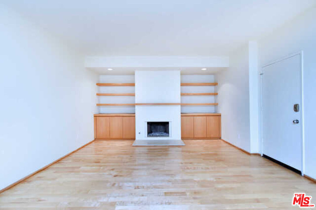 10045 Reevesbury Drive Beverly Hills, CA 90210 - Photo 4 of 32 a view of an empty room with a fireplace and a window