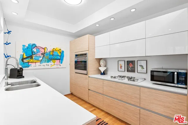 a kitchen with stainless steel appliances a stove a sink and a refrigerator