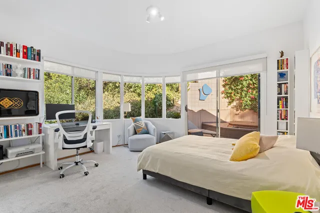 a bedroom with a bed and a large window