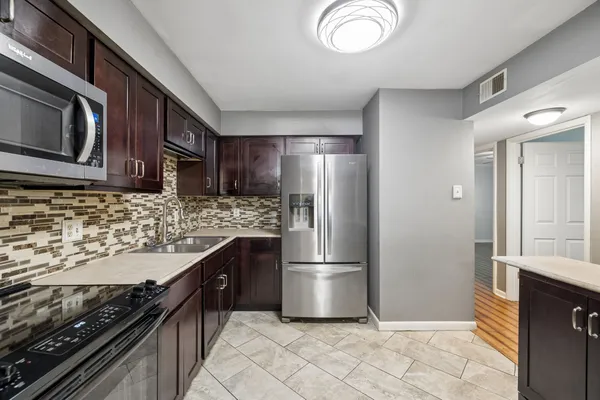 a kitchen with granite countertop a refrigerator stove and microwave