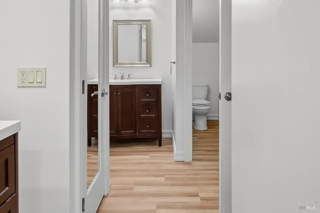 a view of a hallway with wooden floor and staircase