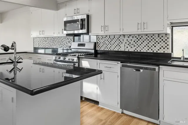 a view of a kitchen with wooden floor and a kitchen counter space