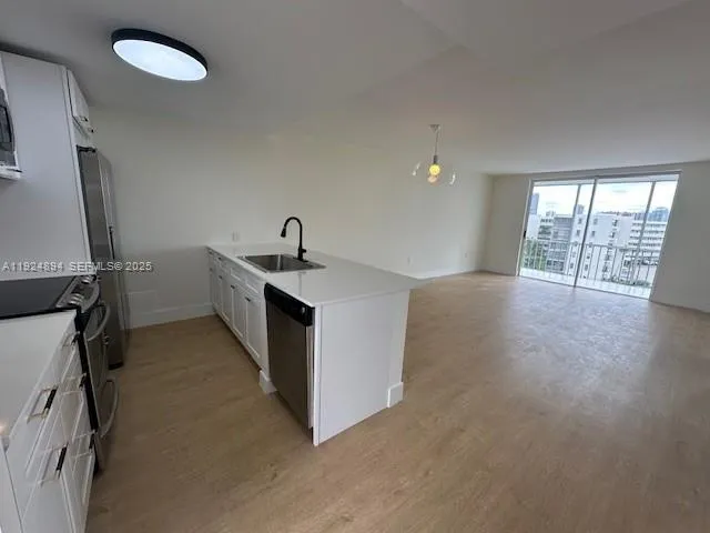 a view of a kitchen with a sink dishwasher and a fireplace