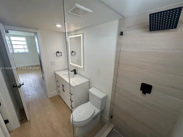 a bathroom with a toilet sink a shower and mirror