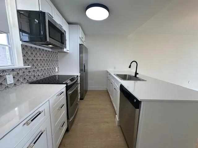 a kitchen with a sink stove and microwave