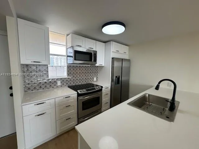a kitchen with a sink appliances and cabinets